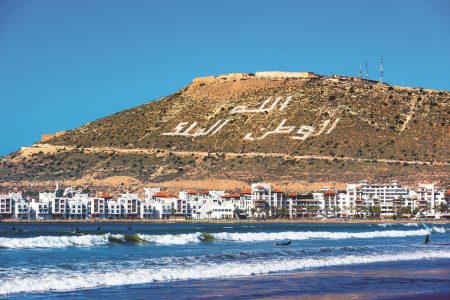 a beach with a hill and buildings